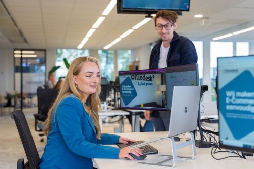 Collega’s bespreken PIM-integratie op werkplek met meerdere schermen